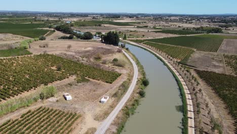 Tourist-boats-on-the-Canal-Du-Midi-South-Of-France,-a-beautiful-way-to-see-the-rural-countryside-of-France-and-the-multitude-of-vineyards-in-the-region