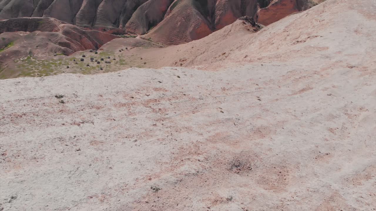 toma cinematográfica de un dron de una montura verde del desierto, aspecto de parque jurásico, cielo azul