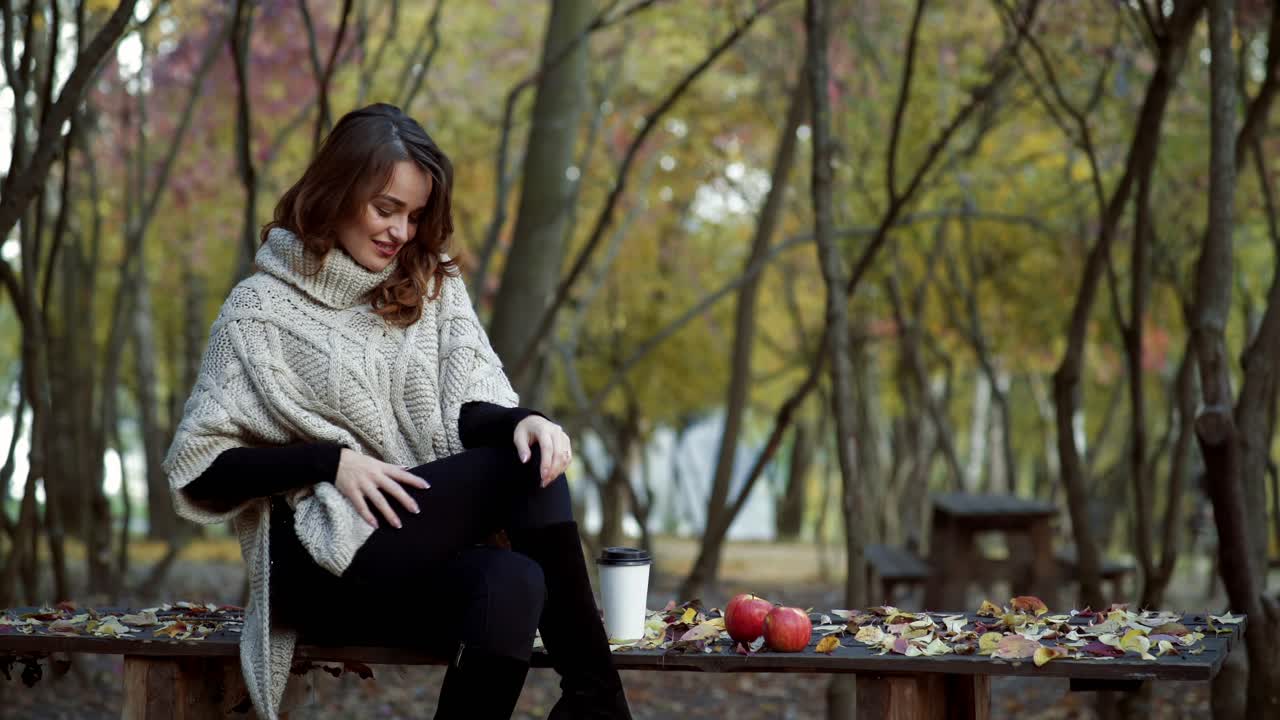 Woman with coffee in park. Young woman relaxing with cup of coffee in park