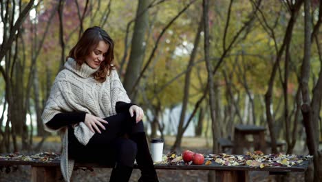 woman with coffee in park. young woman relaxing with cup of coffee in park