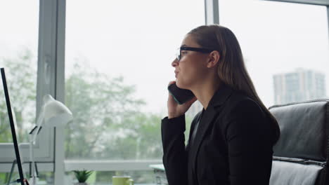 successful businesswoman talking mobile phone closeup. serious manager working