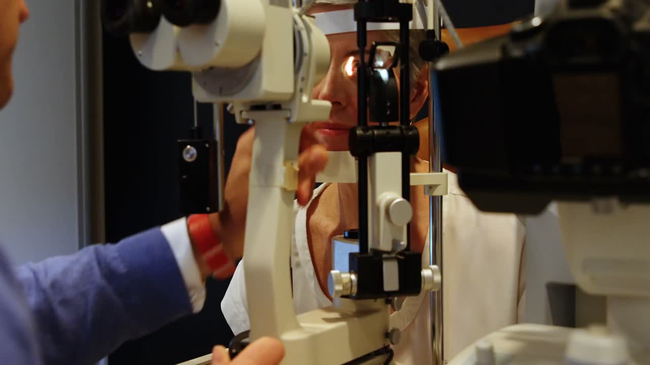 Optometrist examining patient eyes with slit lamp 4k