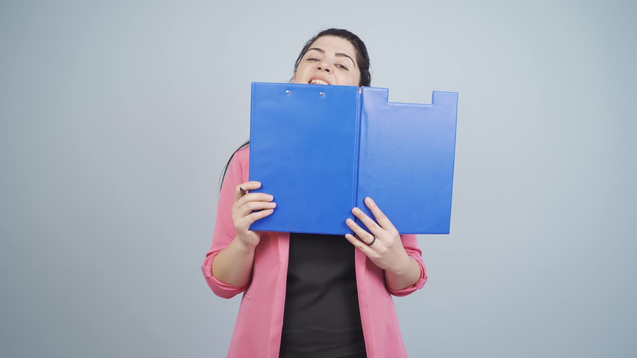 Business woman looking from behind files.
