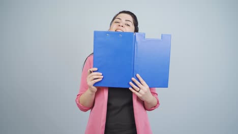 mujer de negocios mirando desde detrás de los archivos.
