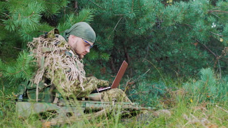 Bewaffnete-Männer-In-Tarnung,-Die-Im-Wald-Sitzen,-Benutzt-Laptop