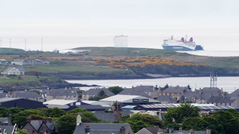 Telephoto-shot-of-a-passenger-ferry-sailing-passed-a-group-of-wind-turbines