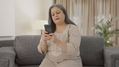 Happy-Indian-old-woman-texting-someone