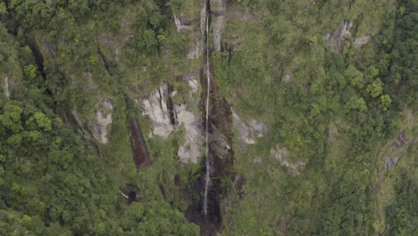 Aerial-pull-back-view-above-Taiwan-jungle-wilderness-cascading-rocky-cliff-waterfall