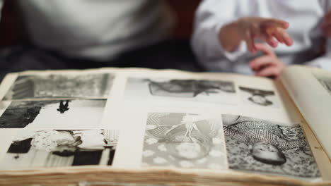 little child hides and strokes granny picture in old album