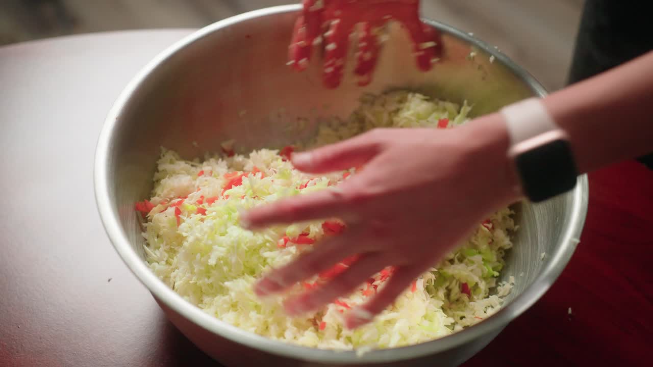 Hand mixing vegetable carrot and cabbage shreds in large bowl