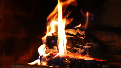 wood burning in a fireplace. warm cozy fire in a fireplace. beautiful orange fire flame over wooden logs. close-up.