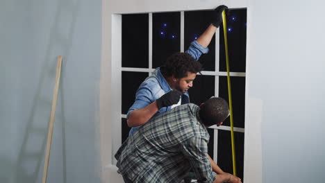 african-american builders measure window height in studio