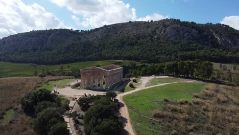 Fly-In-Antenne-Eines-Antiken-Griechischen-Tempels-Und-Seiner-üppigen-Landschaft-An-Einem-Sonnigen-Tag