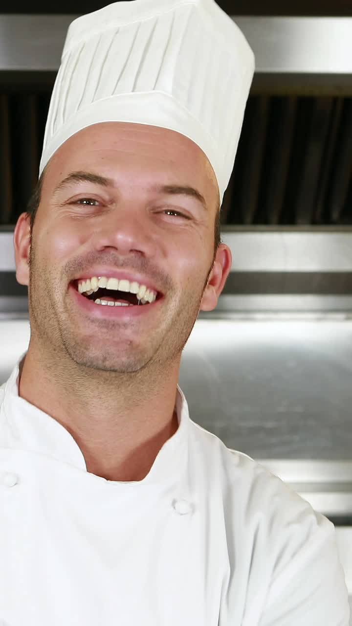 Chef sorridente che mostra un piatto e fa il segno dell'ok