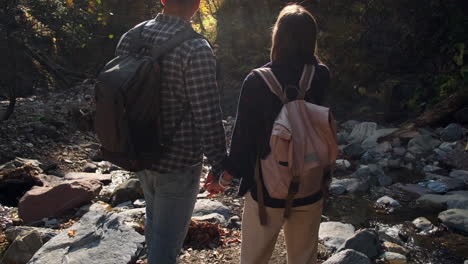 pareja de senderismo en el arroyo del bosque de otoño