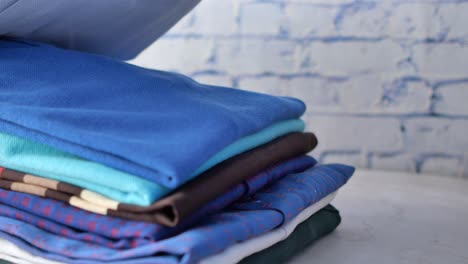 men hand putting shirts on table