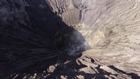 aerial top down shot of burning crater of bromo volcano during sunny day in indonesia