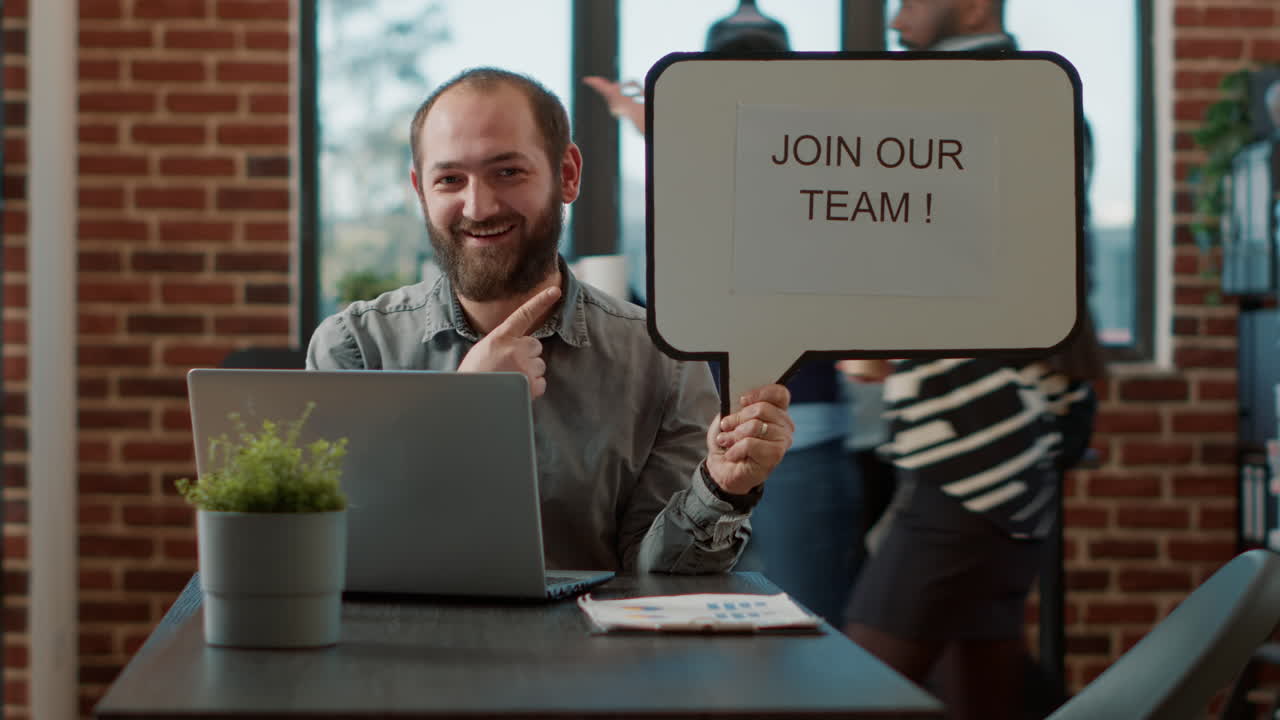 Portrait of cheerful man pointing at speech bubble with hiring ad