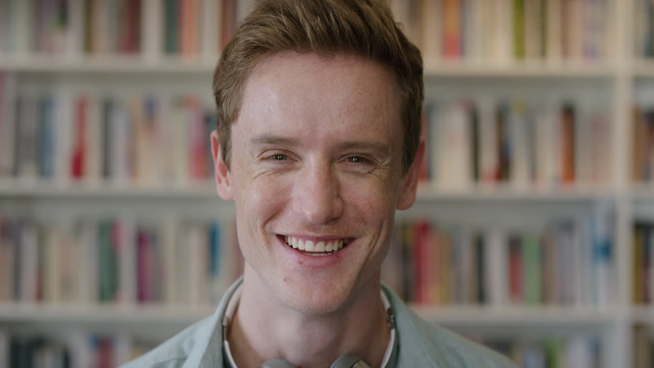 가까운 초상화: 매력적인 젊은 남성, 학생, 웃고, 책상 뒤에서 편안한 대학 생활을 즐기고, 은 머리카락, 얼룩