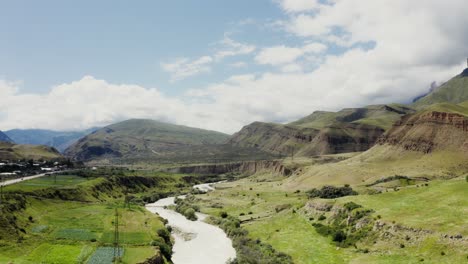 paisaje de valle de montaña con río y nubes