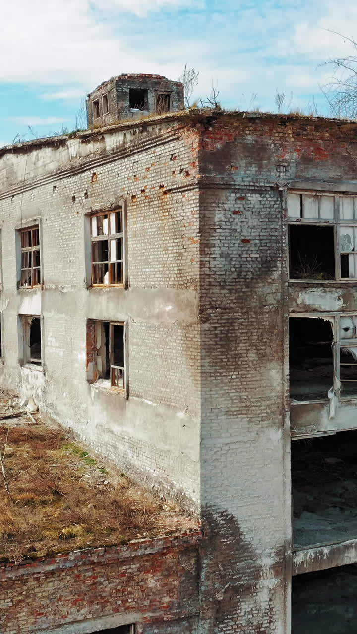 Aerial view of an old factory ruin and broken windows. Old industrial building for demolition. Vertical video