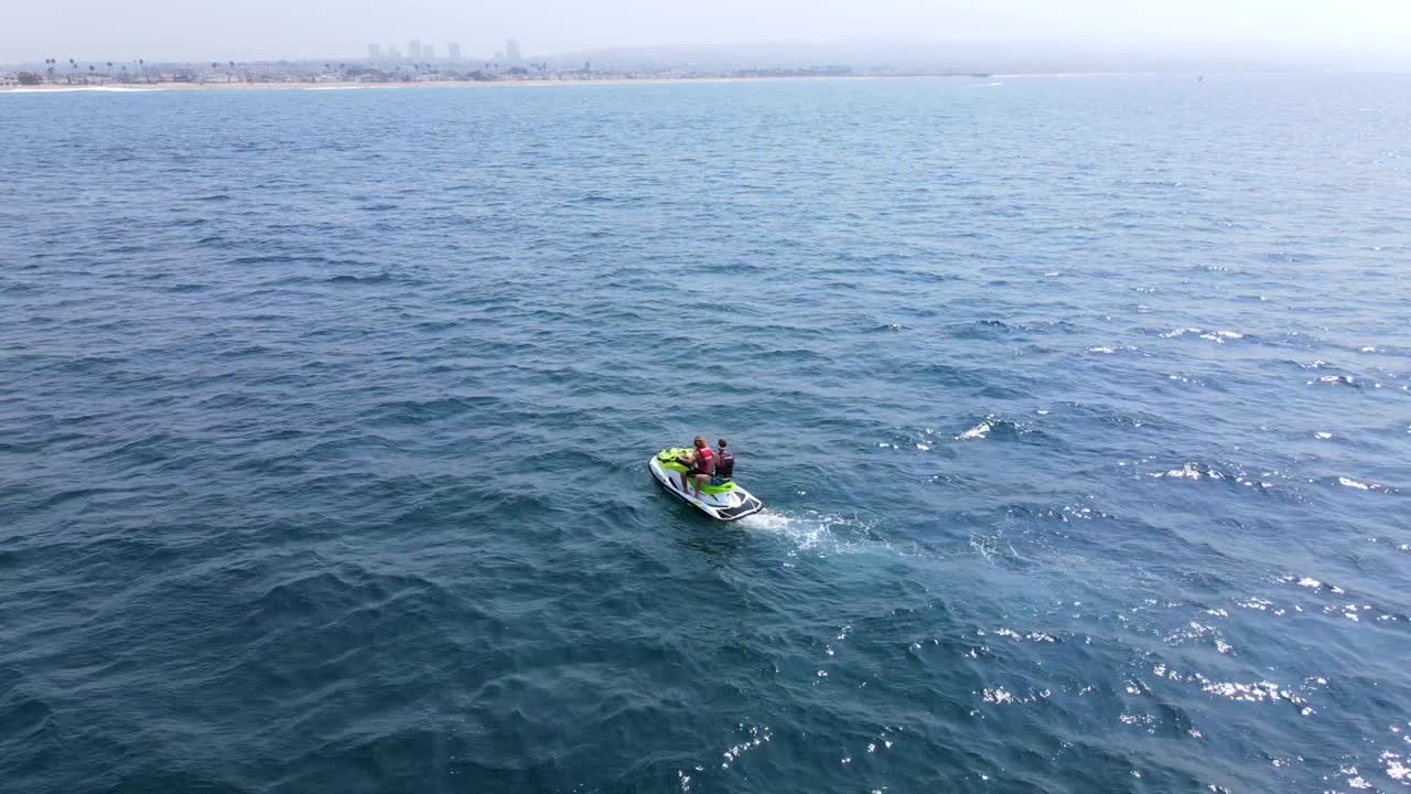 해안에서 멀리 떨어진 제트 스키를 타는 커플의 훌륭한 항공 샷