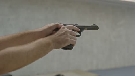 shooter pulling back pistol slide and ejecting life small caliber cartridge