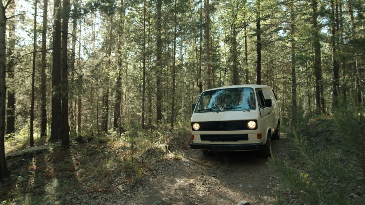 mujer conduciendo una furgoneta en el bosque