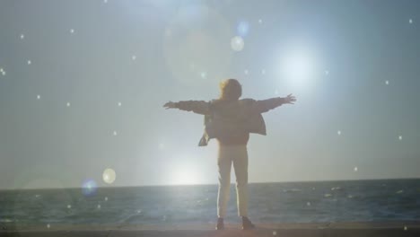 woman staring at the sea with arms wide open