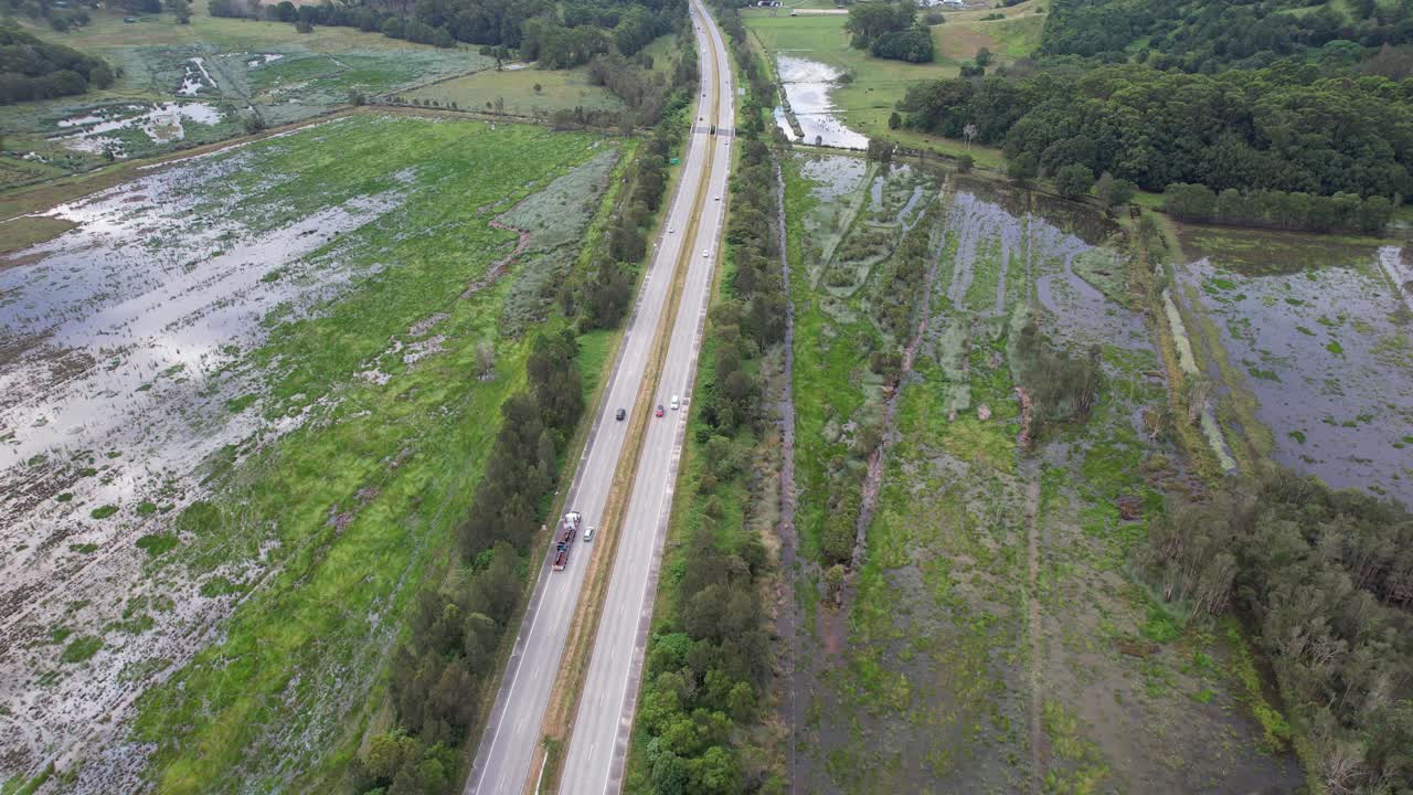conducción panorámica en la autopista del pacífico a través de campos húmedos en tanglewood, nueva gales del sur, australia