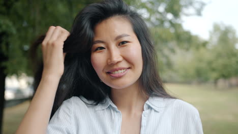 smiling asian woman in a park