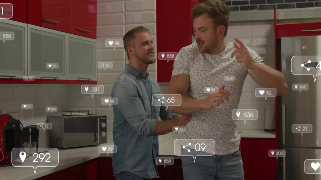 Two male friends dancing inside modern kitchen, featuring floating social media marketing icons