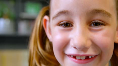 Close-up-of-happy-Caucasian-schoolgirl-standing-in-library-at-school-4k