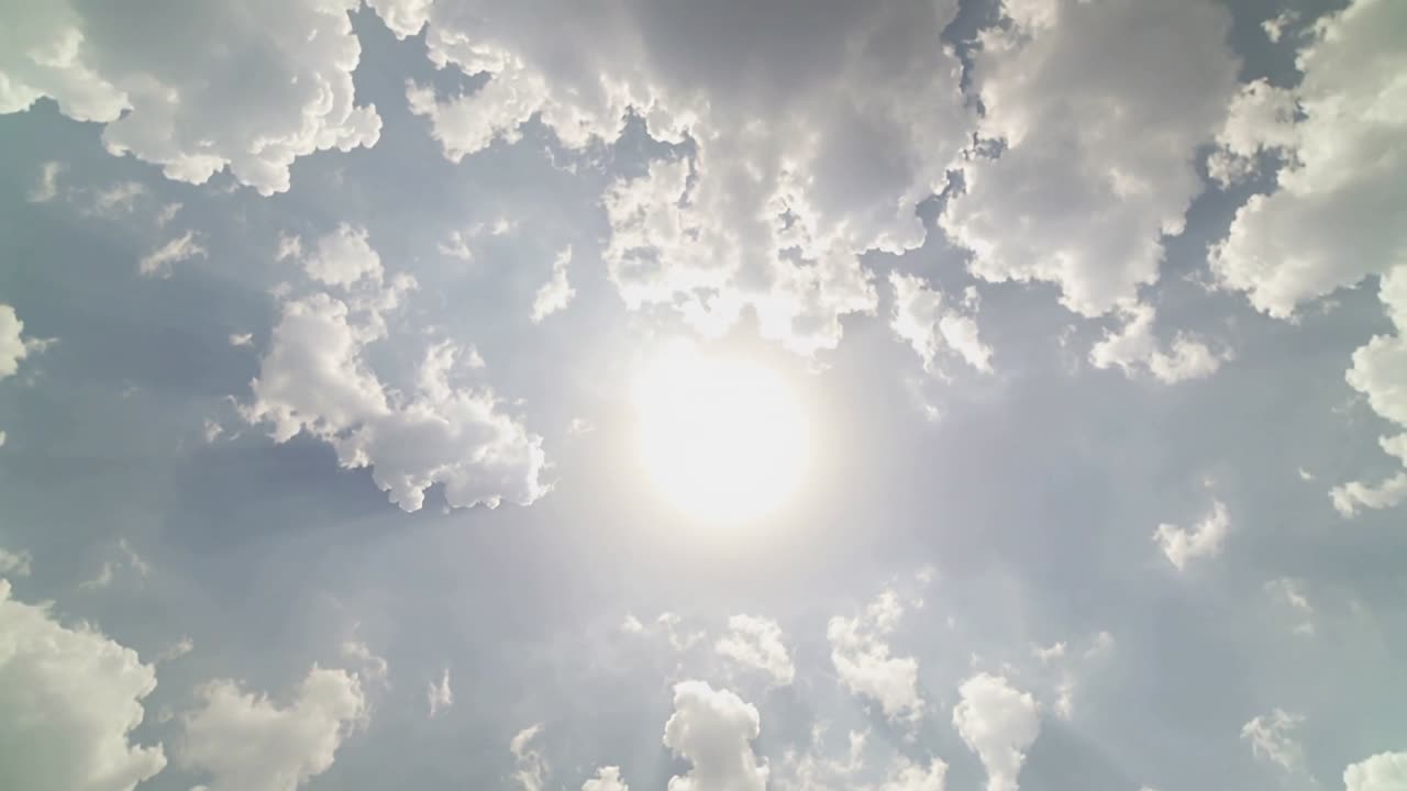 Centered sun and sky showing cloud drift, causing rays softening and glare shifting for weather