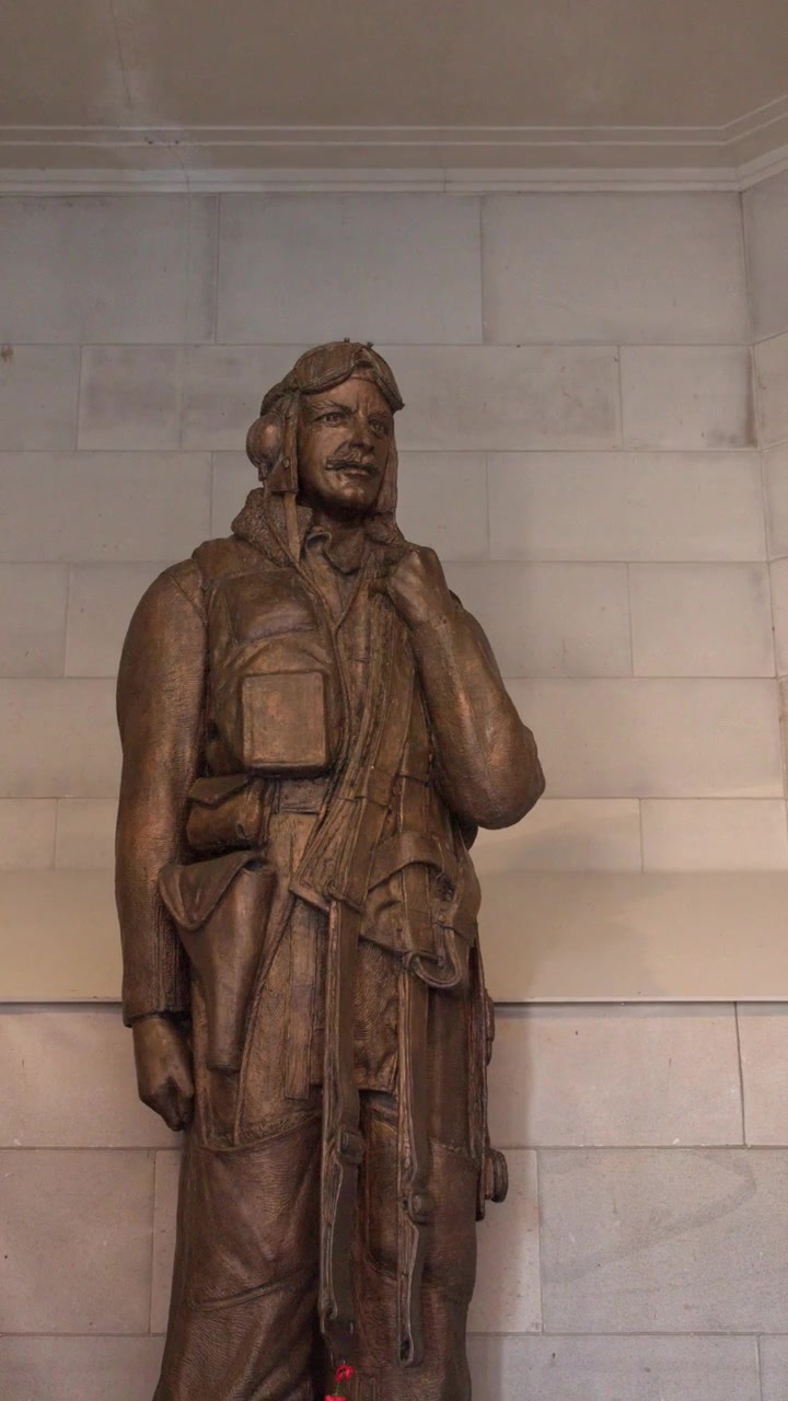 Inquadratura media statica di una statua in bronzo di un aviatore contro un muro di pietra a Canberra, Australia