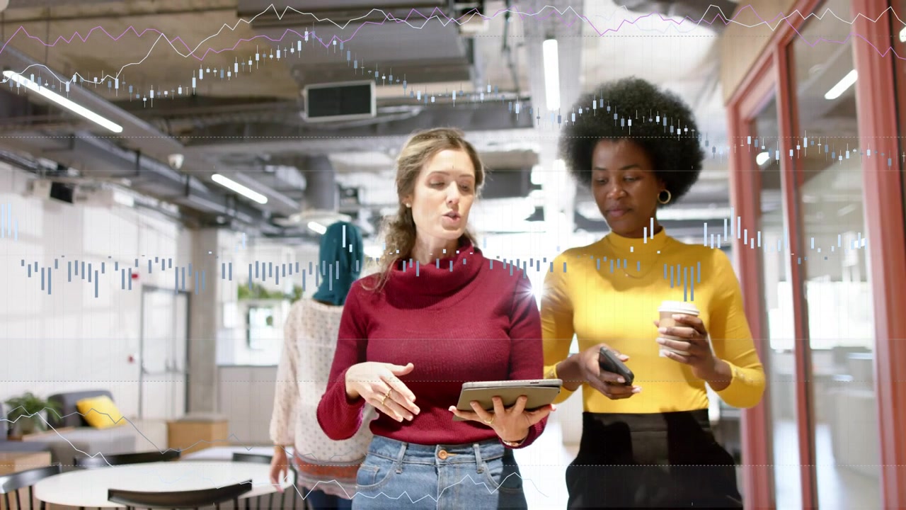 Two women walking, lead tapping tablet causing waveform while colleague checking phone for work