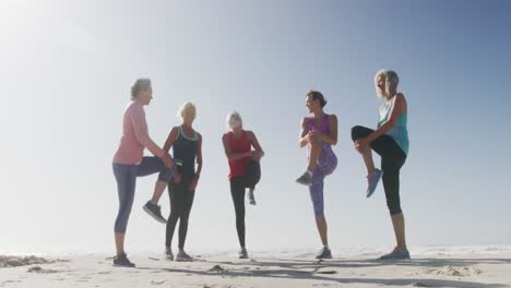 Senior-women-stretching-in-the-beach