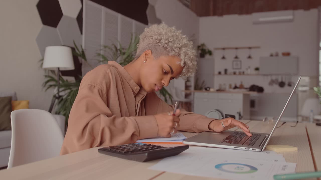 African woman manage budget calculate on pay bills taxes online on laptop