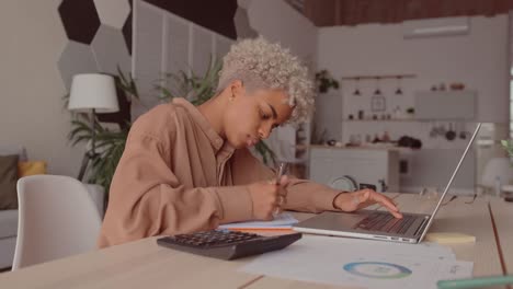 african woman manage budget calculate on pay bills taxes online on laptop