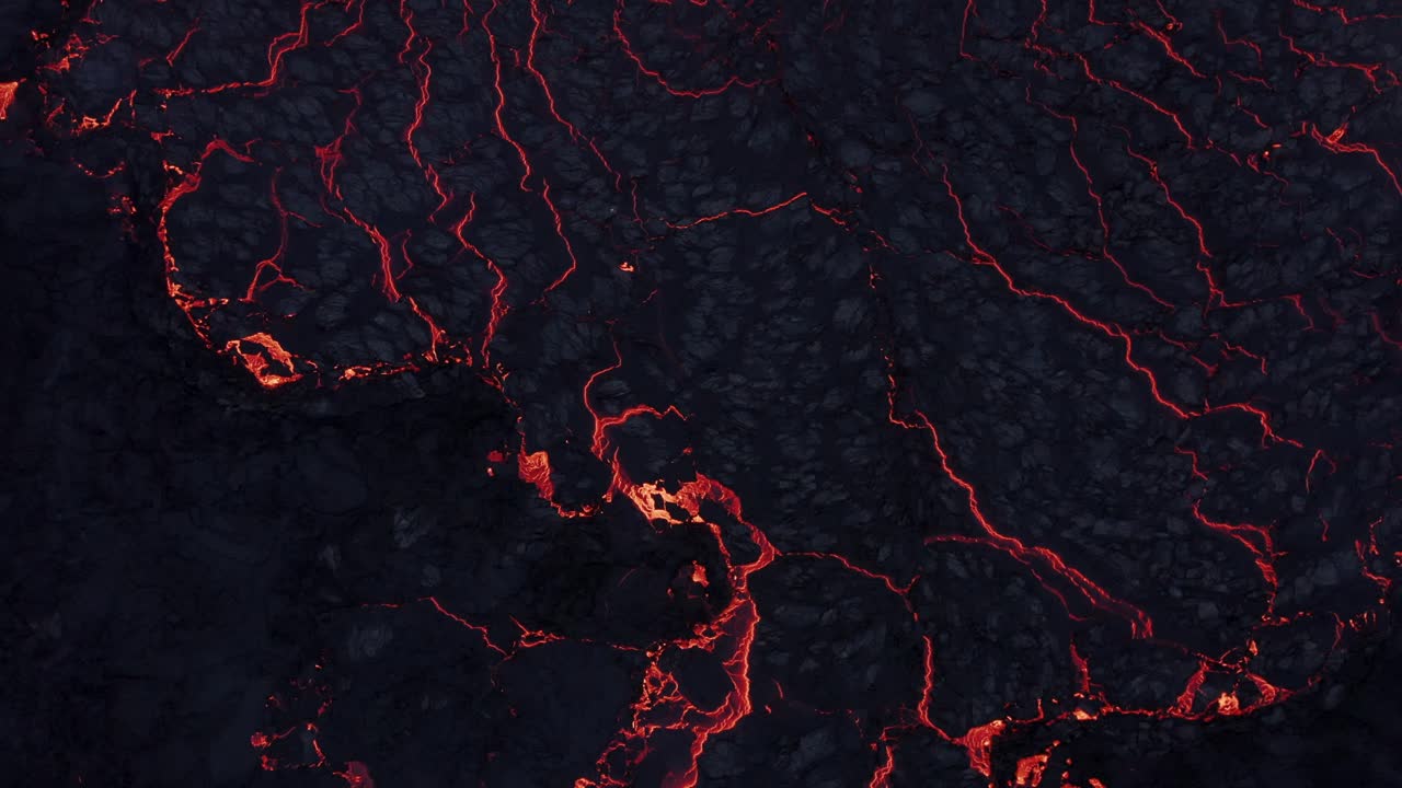 Cracked black solidified basalt rock surface in extreme volcanic active area, top down