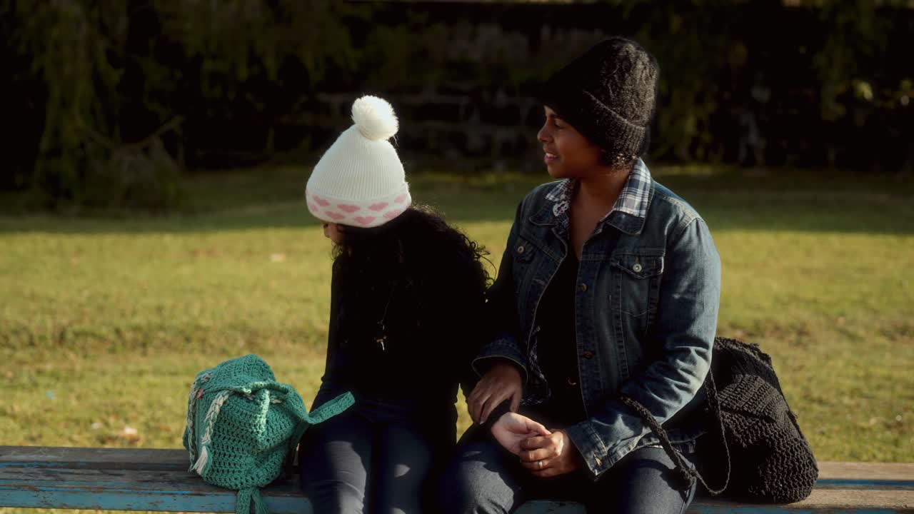 Woman and Child Sitting on a Park Bench