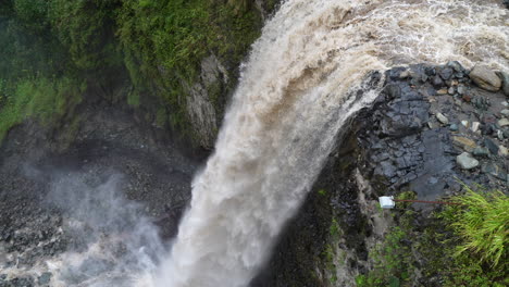 aerial top down showing gigantic waterfall crashing down the cliff in jungle of ecuador - slow motion birds eye view