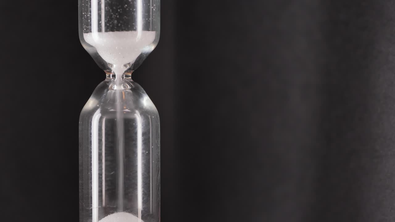 White sand running through bulbs of an hourglass