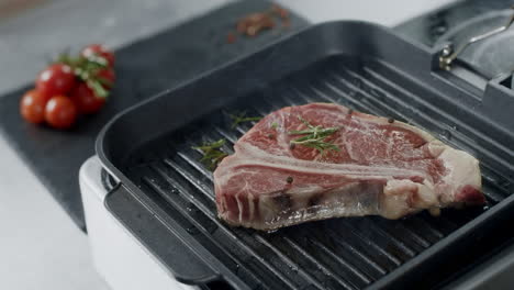 el chef pimienta la carne frita en la parrilla. las manos del hombre cocinando el filete.