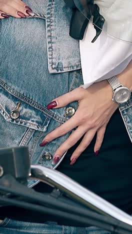 wonderful close view girl hand with wristwatch hugs muscular man on black metal motorcycle against green field