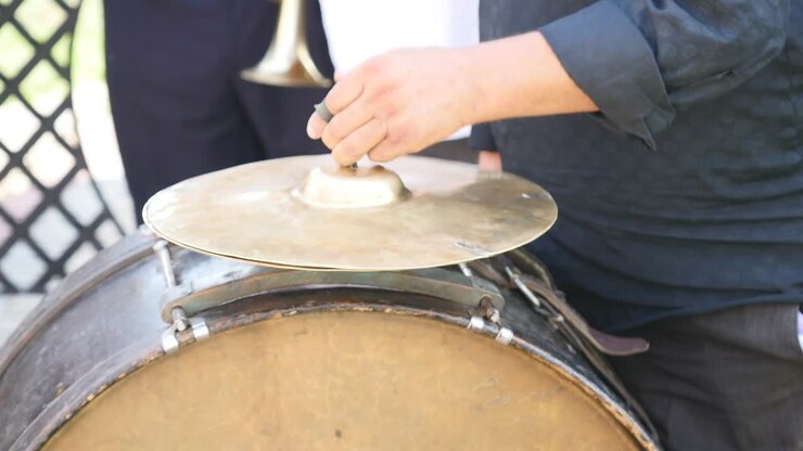 Uomo che suona un tamburo cerimoniale, primo piano.