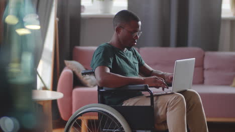 man in wheelchair using laptop