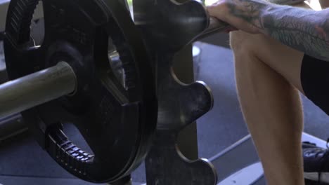 Muscly-man-in-home-gym-exercising-seated-calf-raises-smith-machine