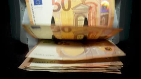 euro banknotes being counted by a machine