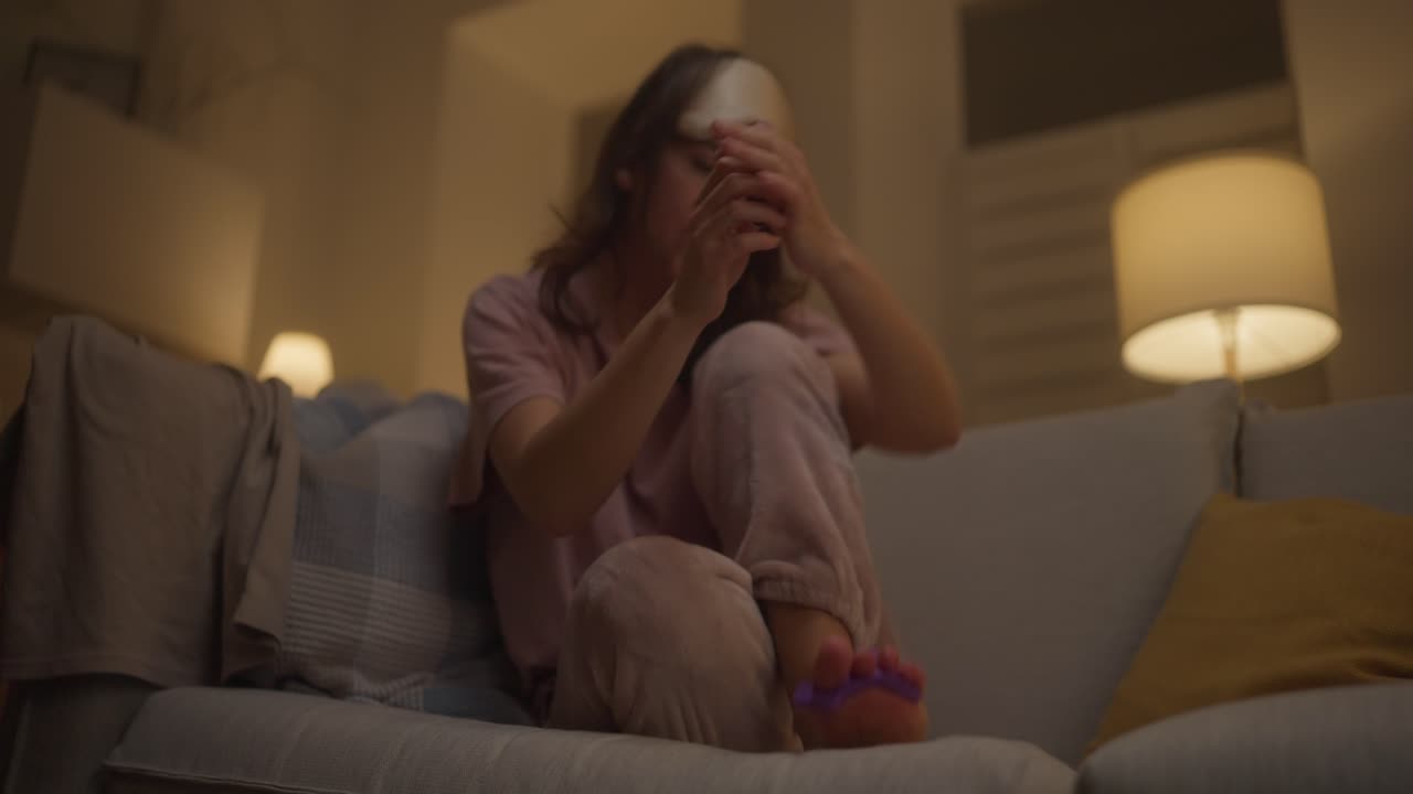 Donna che si fa le unghie di notte sul divano